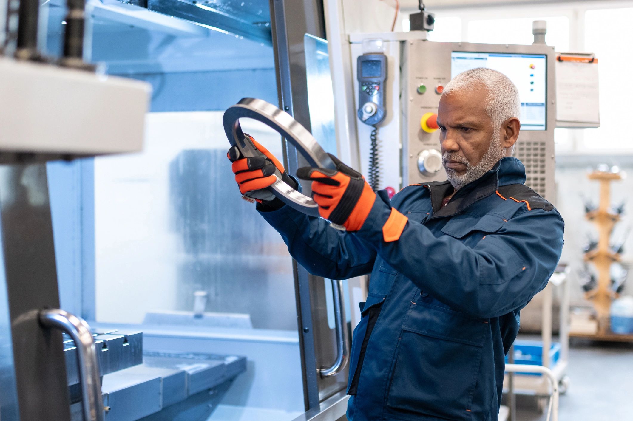 Engineer inspecting a machined component at a production machine